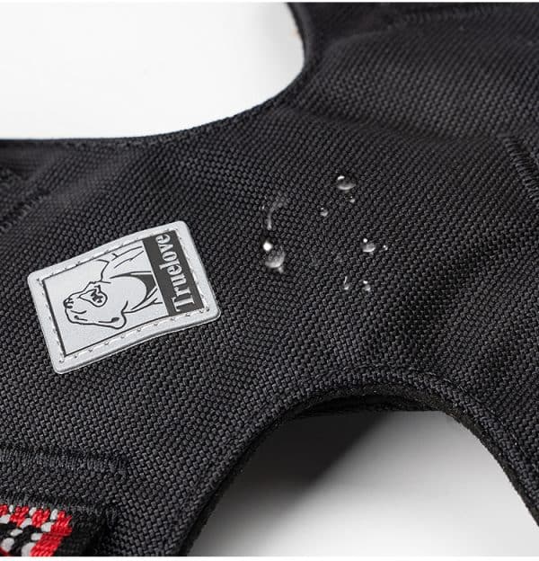 Close-up of the TLH6282 Ultra Light No Pull Harness in black, featuring a "Truelove" brand patch and water droplets, highlighting its water-resistant fabric.
