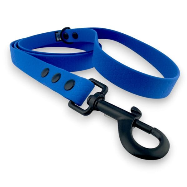 The Wave City Waterproof Dog Lead 1.2m - Hexa Durable is a blue, textured-pattern lead with a black metal clasp and two black buttons, shown coiled neatly on a white background.