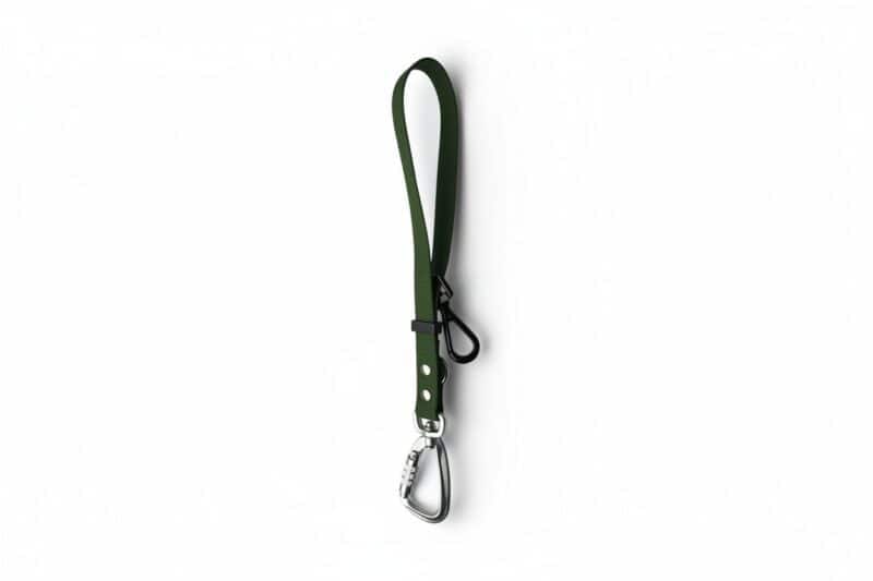 A Freedom Handle in green fabric, featuring a metal carabiner and black plastic clip, designed for hands-free dog walking and convenient multi-dog control, shown isolated on a white background.