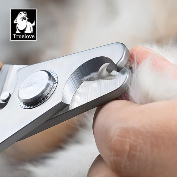 Close-up of a person using the Truelove Heavy-Duty Bamboo Pet Nail Clipper – Large Breed Dog Grooming tool to trim a pet’s claw, with soft fur in the background. The Truelove dog logo is visible in the corner.