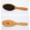 The Truelove Bamboo Pet Grooming Comb – Premium Brush features a black cushioned base and metal bristles, with "Truelove" on the bamboo handle. The brush is displayed from front and back against a white background.