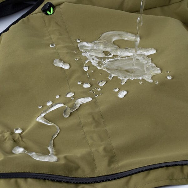 A close-up of the green windproof dog jacket, demonstrating its water-resistant fabric with water droplets rolling off.