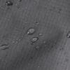 Close-up showing water droplets on the gray waterproof fabric of the Reflective Dog Raincoat, demonstrating its resistance to rain.