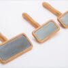 Three Truelove Bamboo Pet Combs – grooming tools with wooden handles and metal bristles – are arranged by size on a white background.