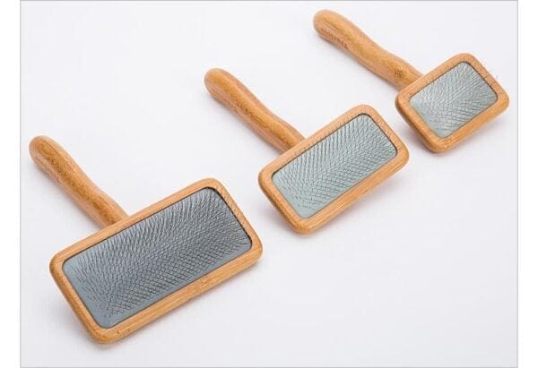 Three Truelove Bamboo Pet Combs – grooming tools with wooden handles and metal bristles – are arranged by size on a white background.