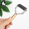 A hand holds the Truelove Bamboo Molting Hair Comb, featuring a bamboo handle and metal comb blades for pet care. A green plant and the Truelove logo appear in the background.