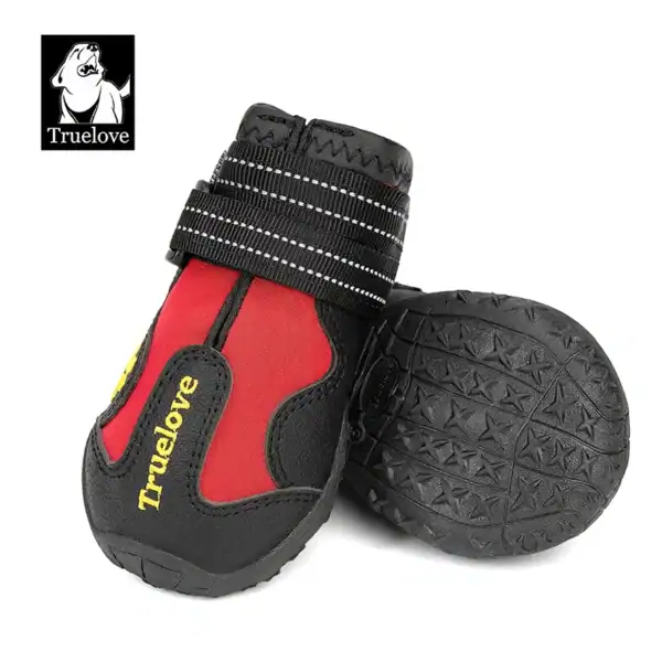 Two black and red Truelove Anti-Slip Dog Shoes with hook & loop closure (TLS3961), non-slip rubber soles, reflective straps, and "Truelove" branding; one shoe stands upright, the other lies on its side to show the sole.