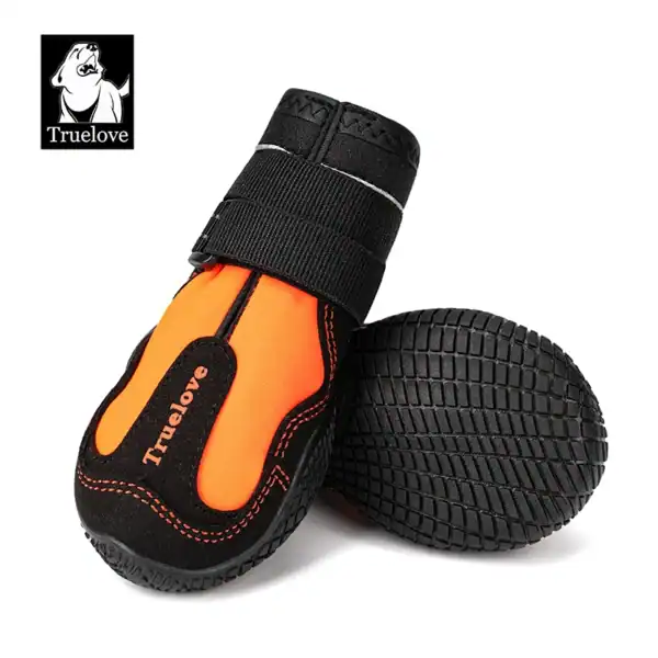 Two orange and black Truelove Outback Boots - Reflective & Traction for Pets TLS4861: one upright showing the Velcro strap and branding, the other on its side revealing the textured rubber sole.