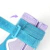 Close-up of a Truelove Waterproof Outdoor Pet Shoes - Reflective Strap TLS3963 in blue and purple, featuring a blue Velcro strap being fastened around the ankle, with a purple arrow showing the securing direction.