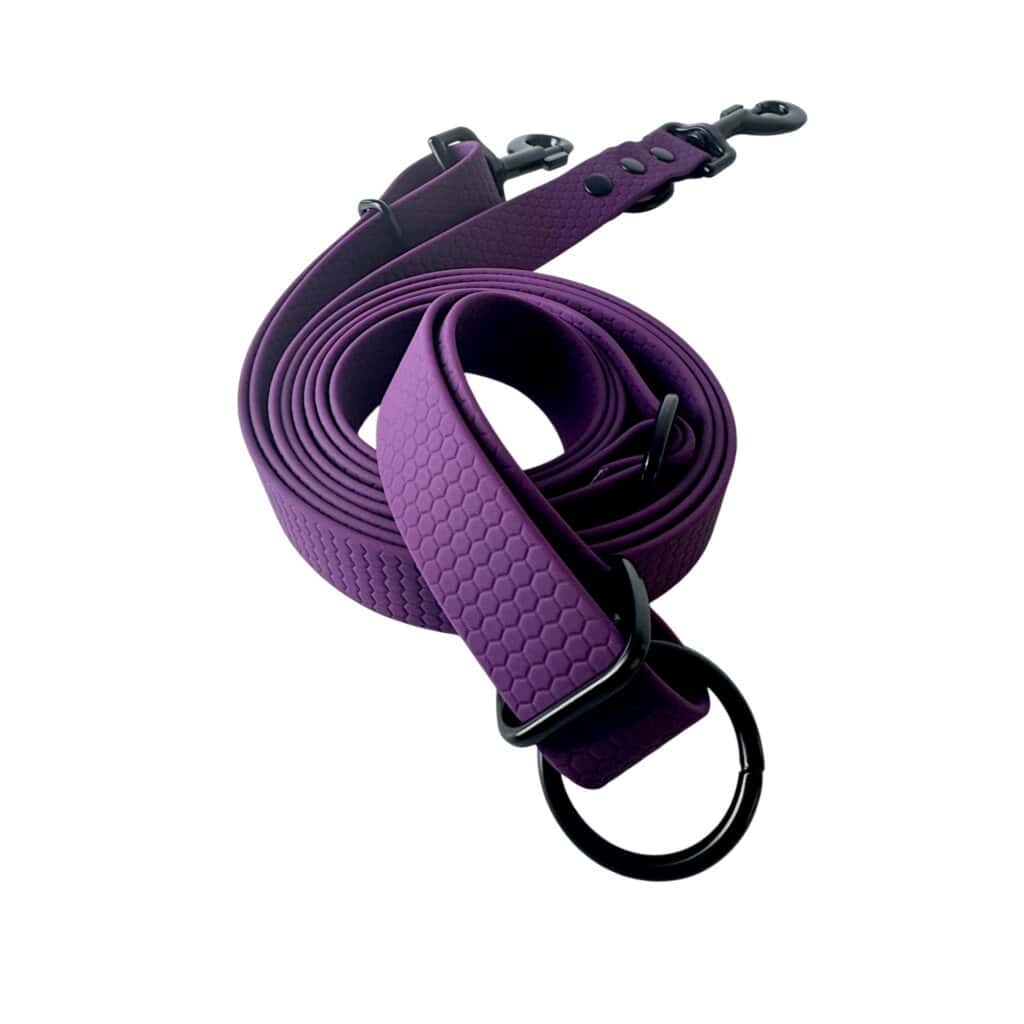 A rolled-up purple dog lead with a hexagonal texture, black metal clasp, and O-ring fittings, displayed on a white background.
