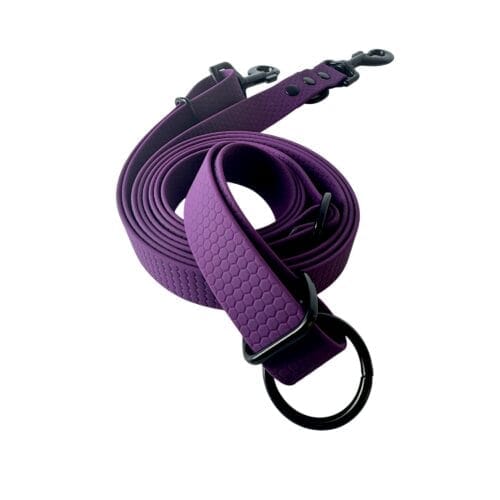 A rolled-up purple dog lead with a hexagonal texture, black metal clasp, and O-ring fittings, displayed on a white background.