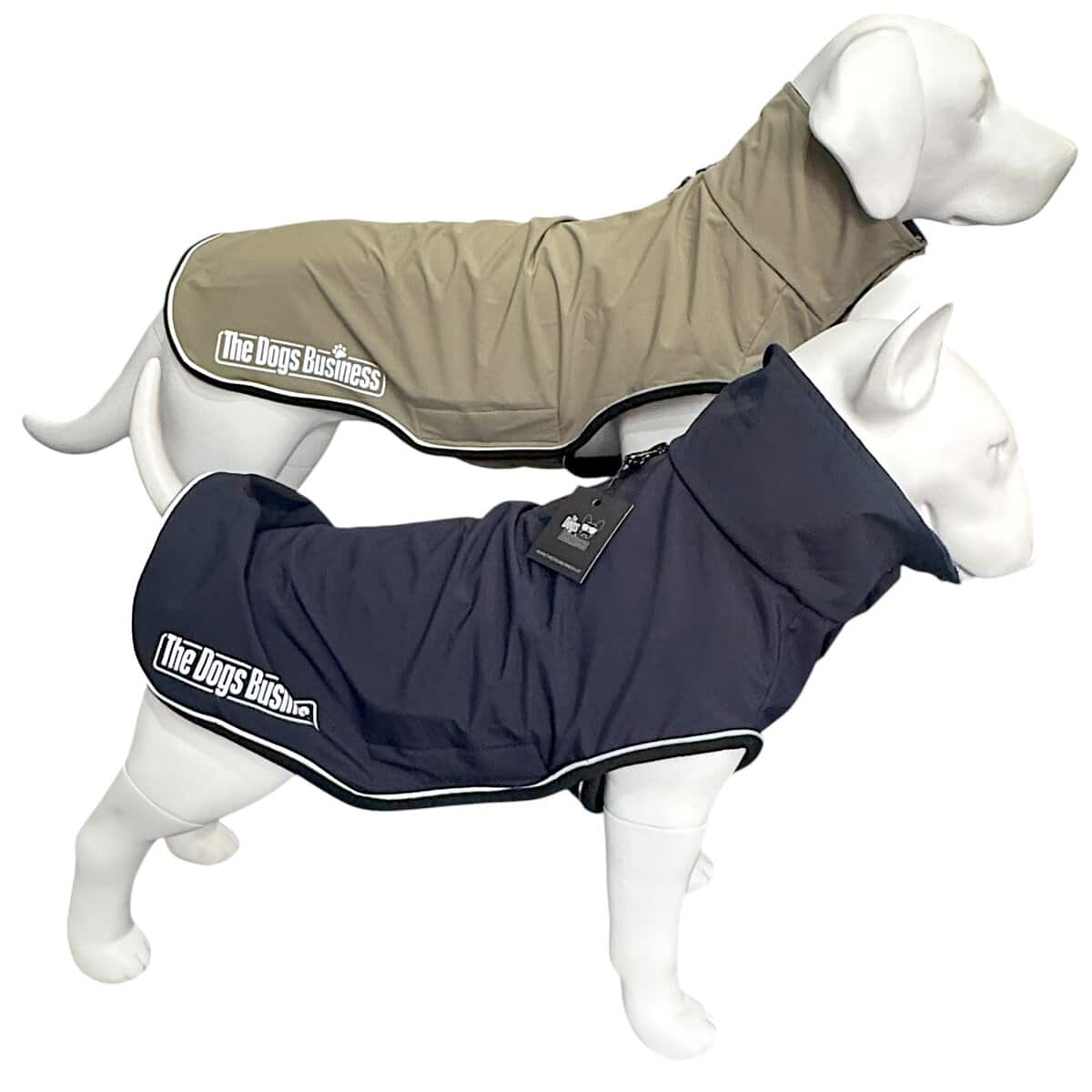Two white dog mannequins wear TDB light Jackets—one tan, one dark blue—each labelled "The Dogs Business." Both coats have high collars, waterproof fleece lining, and white piping along the edges.