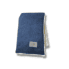 A folded navy blue velour snuggle blanket with a white fleece lining and a grey logo patch.